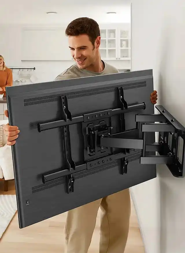 Técnico instalando un soporte para TV en la pared de una casa
